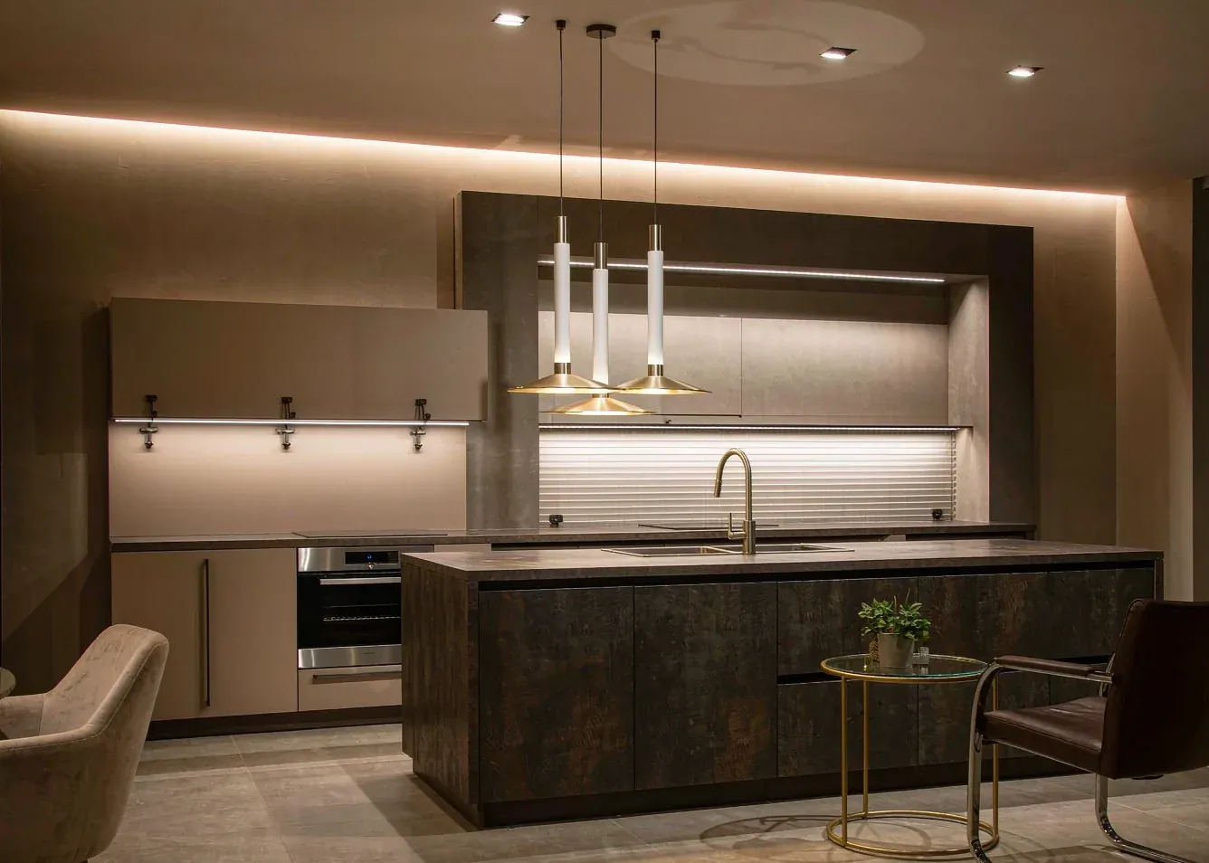 Open plan kitchen at dusk with layered pendant, cove and under-cabinet lighting