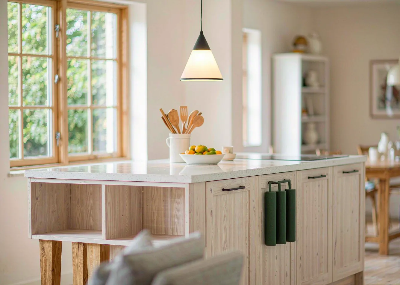 modern kitchen island with white quartz countertop and pale oak cabinetry